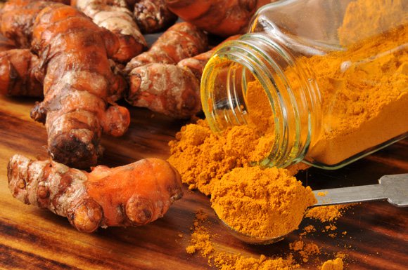 turmeric roots and a jar of turmeric powder